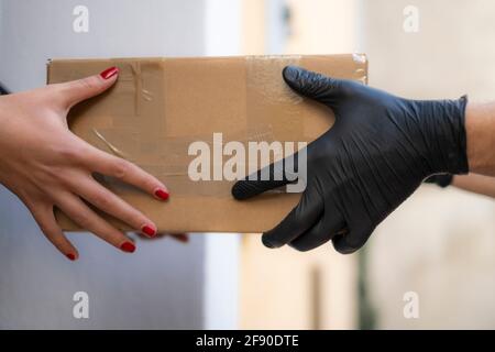 Frau zu Hause Versandpaket von Lieferung Männer, E-Commerce-Shopping zu erhalten Kaufen Stockfoto