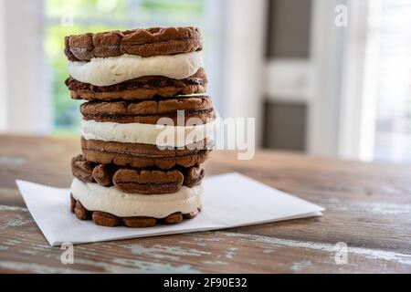 Stapel von drei Schokoladeneissandwiches auf Holztisch Stockfoto