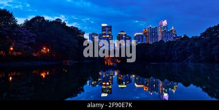 Skyline von Atlanta mit Wolkenkratzern, die sich bei Sonnenuntergang im Wasser spiegeln, Georgia, USA Stockfoto