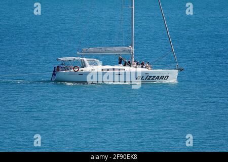 Airlie Beach, Queensland, Australien - 2021. April: Eine Luxusyacht mit Passagieren an Bord, die durch das ruhige blaue Meer fahren Stockfoto