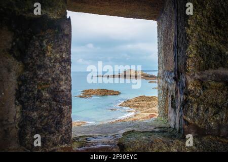 St-Malo, Frankreich, 2020. September, Blick durch eine Öffnung im Wall einer Festung auf Grand Bé, einer Gezeiteninsel Stockfoto