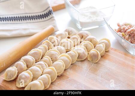 Hausgemachte Knödel auf schönen Holzbrettern, freier weißer Hintergrund Stockfoto