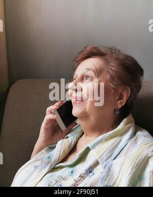 Ältere Frau, die am Handy telefoniert und fröhlich lächelt Stockfoto