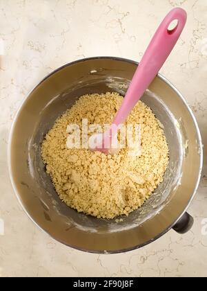 Mischen und Falten aller Zutaten in Metallschüssel mit Gummi Spachtel Stockfoto