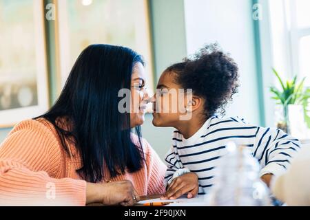 Verspielte Großmutter und Enkelin reiben zu Hause Nasen Stockfoto