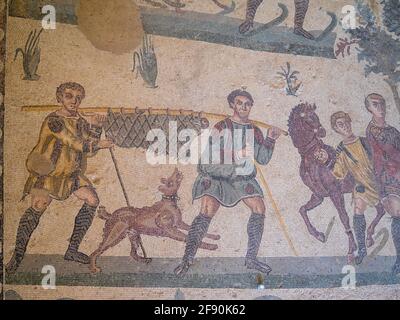 Zwei Mann, der ein Wildschwein in einem Netz trägt, Mosaikdetails aus dem Raum der kleinen Jagd, Villa Romana del Casale Stockfoto