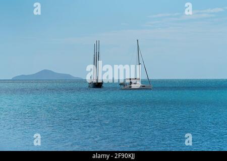 Airlie Beach, Queensland, Australien - April 2021: Luxusyachten vor Anker auf einem ruhigen blauen Meer Stockfoto