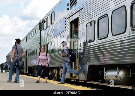 Bartlett, Illinois, USA. Passagiere verlassen einen ausgehenden Metra-Pendlerzug, nachdem sie am S-Bahnhof angekommen sind. Stockfoto