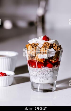 Veganes Kleingebäck, Kokos-Chia-Samenpudding, Kirsch- und laktosefrei, glutenfreier Schokoladenkuchen-Dessert im Glas Stockfoto