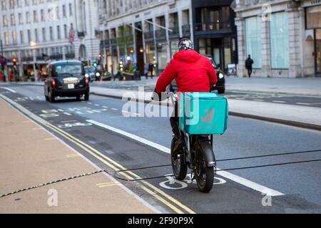 London, Großbritannien. April 2021. Der deliveroo-Fahrer sah, wie er in der Regent Street, London, Essen zum Mitnehmen lieferte. Quelle: Pietro Recchia/SOPA Images/ZUMA Wire/Alamy Live News Stockfoto