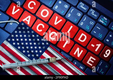 COVID-19-Immunisierung in den USA mit Spritze und Gesichtsmaske mit amerikanischer Flagge und Impfhinweis auf der Computertastatur. Konzept des Covid-Impfstoffes Stockfoto