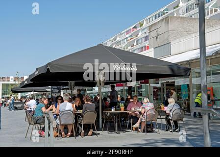 Carluccio's Café Leute sitzen und essen draußen unter der Baldachin oder zelten in strahlendem Sonnenschein, Brunswick Centre Bloomsbury London Borough of Camden UK Stockfoto