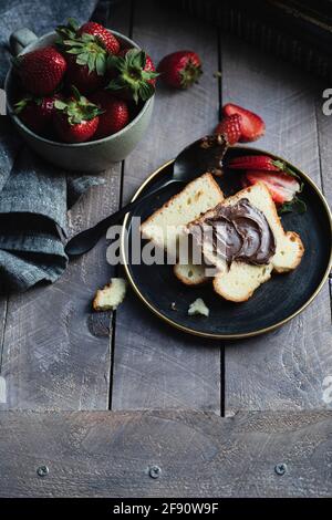 Frühstücksteller mit Biskuitkuchen und Erdbeeren Stockfoto