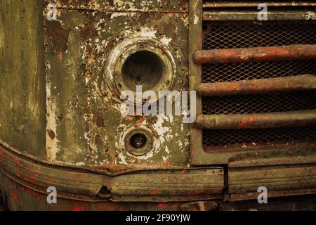 Rostiger Retro-Bus mit kaputten Scheinwerfern aus der Nähe. Stockfoto