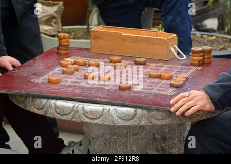 Ein paar Männer spielen auf den Straßen Shanghais ein lockeres chinesisches Schach oder Xiangqi. Stockfoto