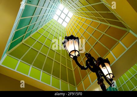 Sonnenlicht durch ein vertikales Oberlicht auf einem geometrischen Atriumturm Mit kräftigen Farben als abstrakter Architektur-Hintergrund Stockfoto