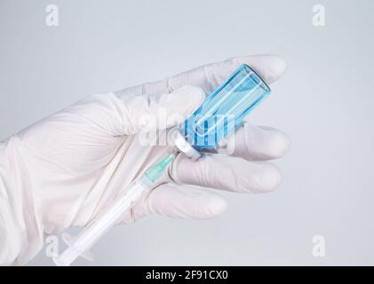Handschuhen mit einer Spritze. Coronavirus, Covid 19, Impfstofffläschchen Stockfoto