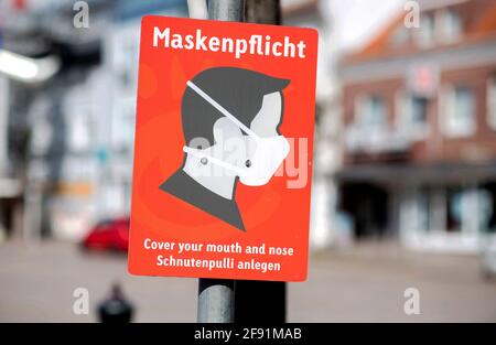 Aurich, Deutschland. April 2021. Auf dem Marktplatz in der Innenstadt hängt ein Schild mit der Aufschrift „Masken obligatorisch“. Quelle: Hauke-Christian Dittrich/dpa/Alamy Live News Stockfoto