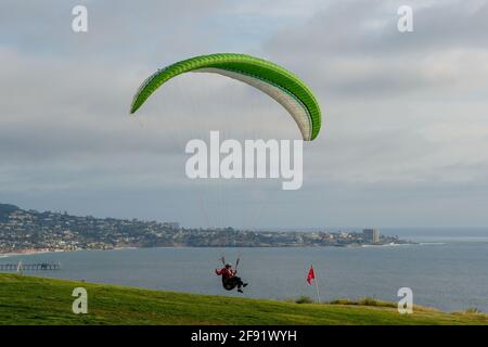 Mann, der Sport macht, Paragleiter im bewölkten Himmel. Paragliding ist ein Extremsport und Erholung. Torrey Pines Gliderport. San Diego. Kalifornien, USA. März 2021 Stockfoto