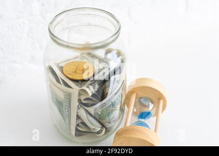 Faltet Geld in einem Glas auf einem weißen Holzhintergrund. Der Ort des Hintergrundbildes für Text. Stockfoto