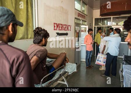 Ein junges Unfallopfer in recht gutem Geist wartet vor der Notaufnahme eines ländlichen Krankenhauses in Rajasthan, Indien Stockfoto