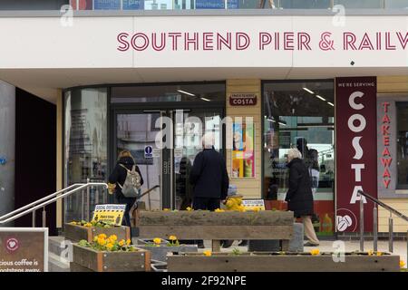 Rückansicht einer Gruppe von Menschen, die den Southend Pier & Railway betreten und nach einer langen, nationalen Sperre in Großbritannien die Gelegenheit zur Freizeitgestaltung genießen, Stockfoto
