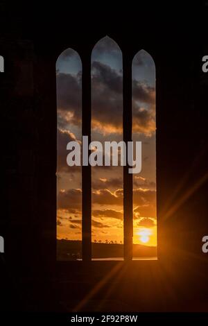 Timoleague, West Cork, Irland. April 2021. Die Sonne geht spektakulär über dem Franziskanerkloster in Timoleague auf als Auftakt zu einem überwiegend trockenen Tag mit trüben Sonnenstrahlen. Die Abtei wurde 1240 gegründet und überlebte, bis sie 1642 von englischen Soldaten verbrannt wurde. Quelle: AG News/Alamy Live News Stockfoto