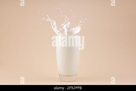 Spritzt Milch in ein Glas. Farbiger Hintergrund. Stockfoto