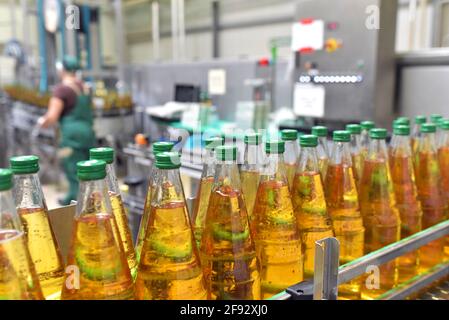 apfelsaft in Glasflaschen in einer Fabrik für die Lebensmittelindustrie - Abfüllung und Transport Stockfoto