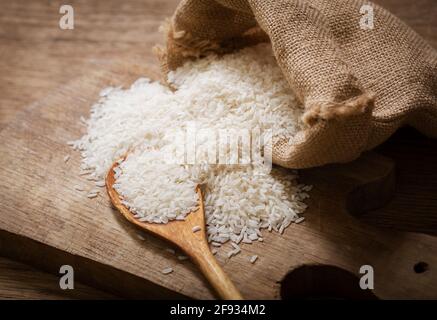 Nahaufnahme von rohem weißem Reis auf einem Holzbrett Stockfoto