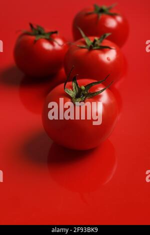 Reift Tomaten auf rotem Hintergrund Stockfoto