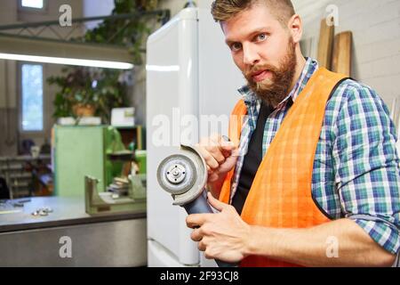 Handwerker als Schlosser mit Winkelschleifer in der Schlosserwerkstatt Für den Metallbau Stockfoto
