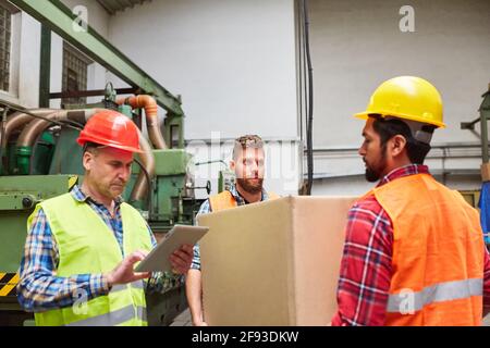 Kommissionierer und Lagerarbeiter mit einem Paket während eines Inspektion im Lager Stockfoto