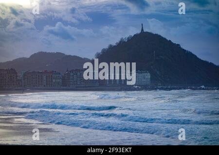 San Sebastian, Spanien - 19. Feb 2021: Sonnenuntergang über dem Monte Urgull vom Strand von Zurriola Stockfoto