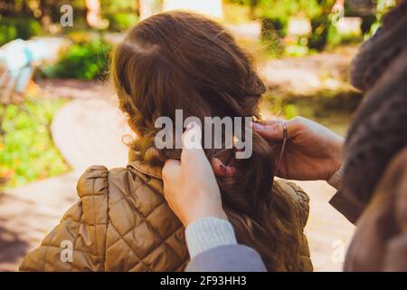 Die Mutter flechtete die Haare ihrer Tochter Stockfoto