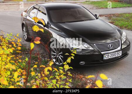 Tschernihiw, Ukraine - 5. November 2018: Schwarzes Auto Lexus es. Baumzweige im Vordergrund Stockfoto