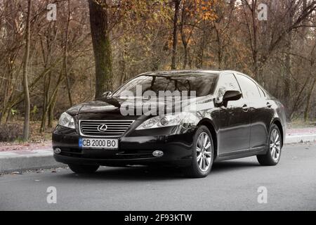 Tschernihiv, Ukraine - 5. November 2018: Schwarzes Lexus es-Auto auf der Straße vor einem Hintergrund von Bäumen Stockfoto