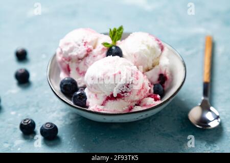 Hausgemachter Joghurt und Heidelbeer-Eis mit natürlicher Heidelbeere Eine Schale auf einem rauhen blauen Hintergrund Stockfoto