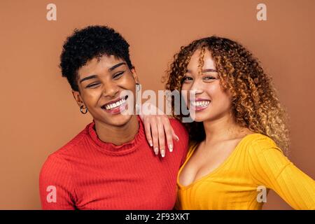 Stock Foto von schönen afro Frauen posiert im Studio vor braunem Hintergrund geschossen. Stockfoto