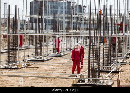 Atyrau/Kasachstan - Mai 21 2012: Ölraffinerie-Anlage in Wüstenrenovierung. Arbeiter, Baugerüste und Verstärkungsstahl. Stockfoto