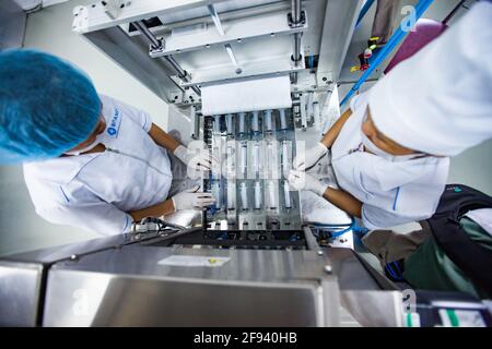 Atyrau, Kasachstan. Produktionsanlage für medizinische Spritzen. Zwei asiatische Frauen an der Produktionslinie. Stockfoto