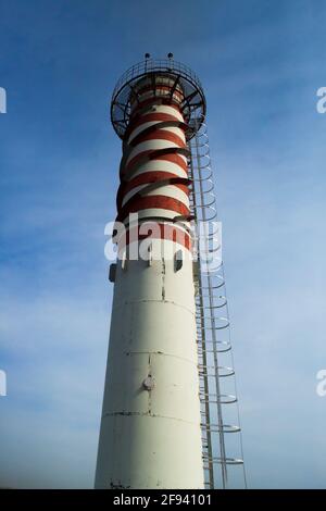 Modernes Gaskraftwerk, das auf blauem Himmel verraucht. Rot gestrichene Streifen. Rotes Licht für die Sicherheit von Flugzeugen oben. Uralsk Stadt, Kasachstan Stockfoto