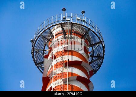 Modernes Gaskraftwerk, das auf blauem Himmel verraucht. Rot gestrichene Streifen. Rotes Licht für die Sicherheit von Flugzeugen oben. Nahaufnahme. Uralsk Stadt, Kasachstan Stockfoto