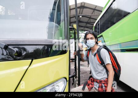 Potrait asiatische junge Mann trägt Gesichtsmasken bekommen auf die Bus Stockfoto