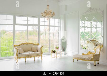 Weißrussland, Minsk - 05. Mai 2020: Möbel in einem hellen, eleganten weißen luxuriösen Interieur mit großem Glas, einem Fenster und einem Kronleuchter. Stockfoto