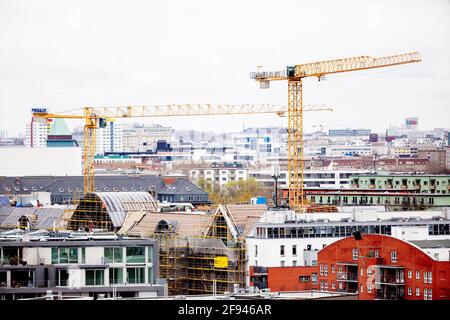 Berlin, Deutschland. April 2021. Zwischen den Gebäuden ragen Baukrane aus. Eine Gebäudefassade spiegelt sich in einer anderen Fassade in Berlin-Kreuzberg wider. Das Bundesverfassungsgericht hatte das seit mehr als einem Jahr geltende Berliner Mietdeckelgesetz in einer am Donnerstag verkündeten Entscheidung für nichtig erklärt. Quelle: Christoph Soeder/dpa/Alamy Live News Stockfoto