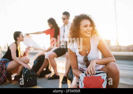 Vier Freunde machen Urlaub in einer Stadt und machen eine Pause, um sich von einem langen Spaziergang an einem schönen Tag auszuruhen. Stockfoto