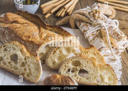 Knuspriges französisches Weißbrot auf rustikalem Holztisch, dekoriert im Landhausstil Stockfoto