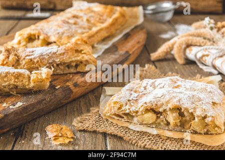 Traditioneller hausgemachter Apfelstrudel auf einem rustikalen Holztisch Stockfoto