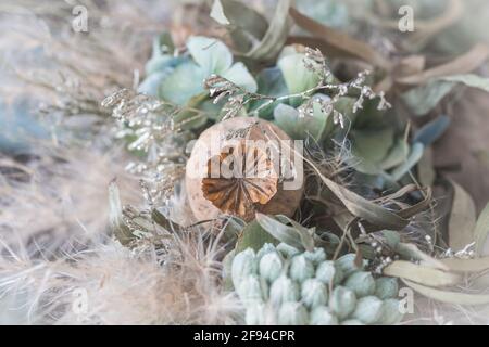 Nahaufnahme eines Kranzes mit getrockneten Blumen in hellgrün Und weiße Winterfarben Stockfoto